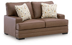 Caramel-brown loveseat with two patterned throw pillows