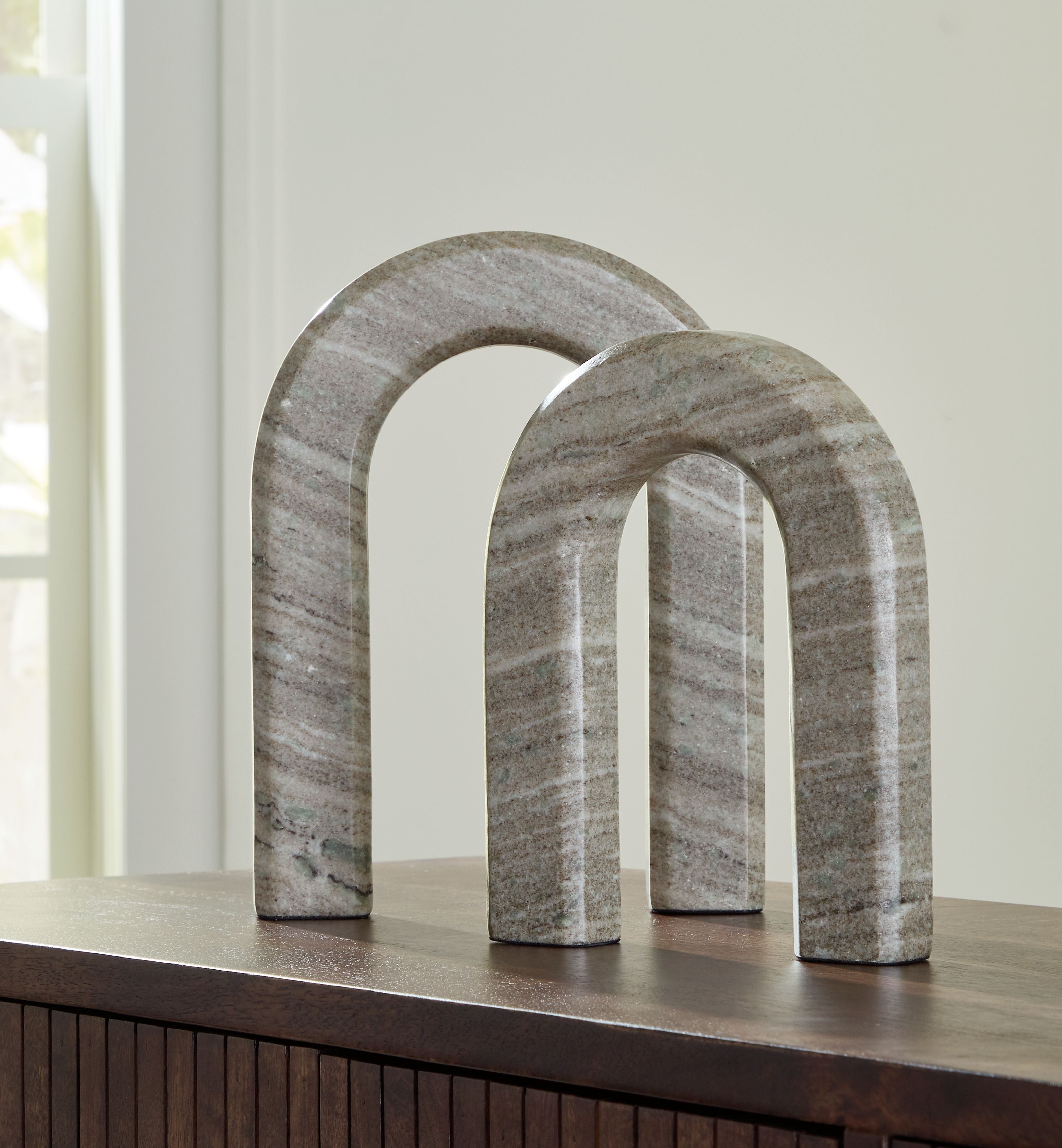 Taupe-gray stone arch sculptures set of 2 on dark wood shelf, curved arch forms.