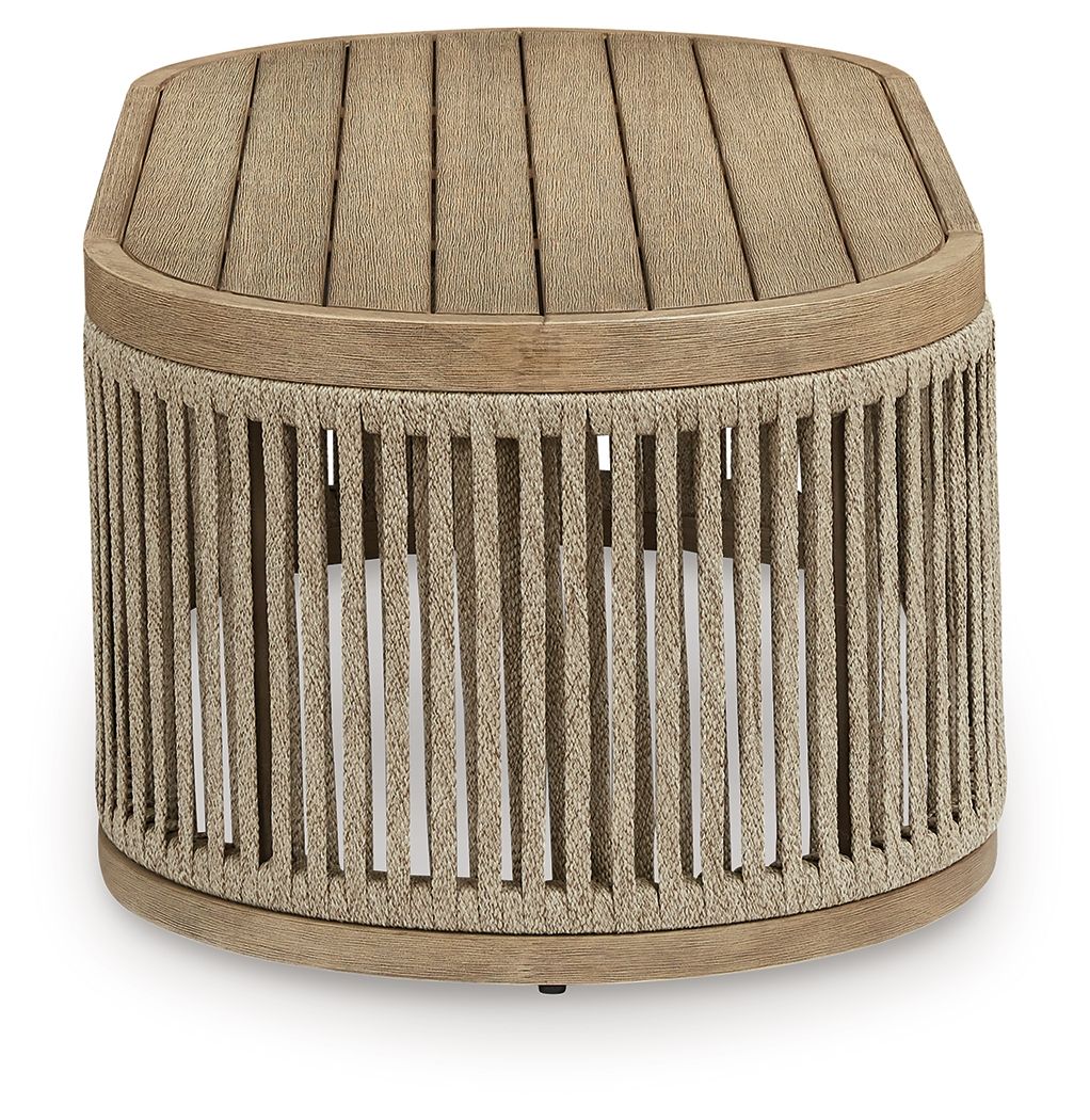 Beige round cocktail table with textured fabric top and vertical slatted sides