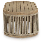 Beige round cocktail table with textured fabric top and vertical slatted sides