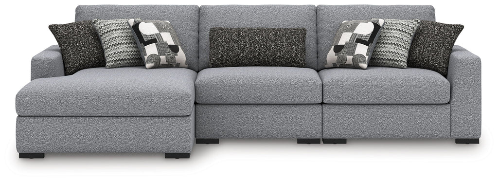 Sectional sofa in light gray with three seats, dark accent pillows and patterned cushions