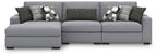 Sectional sofa in light gray with three seats, dark accent pillows and patterned cushions