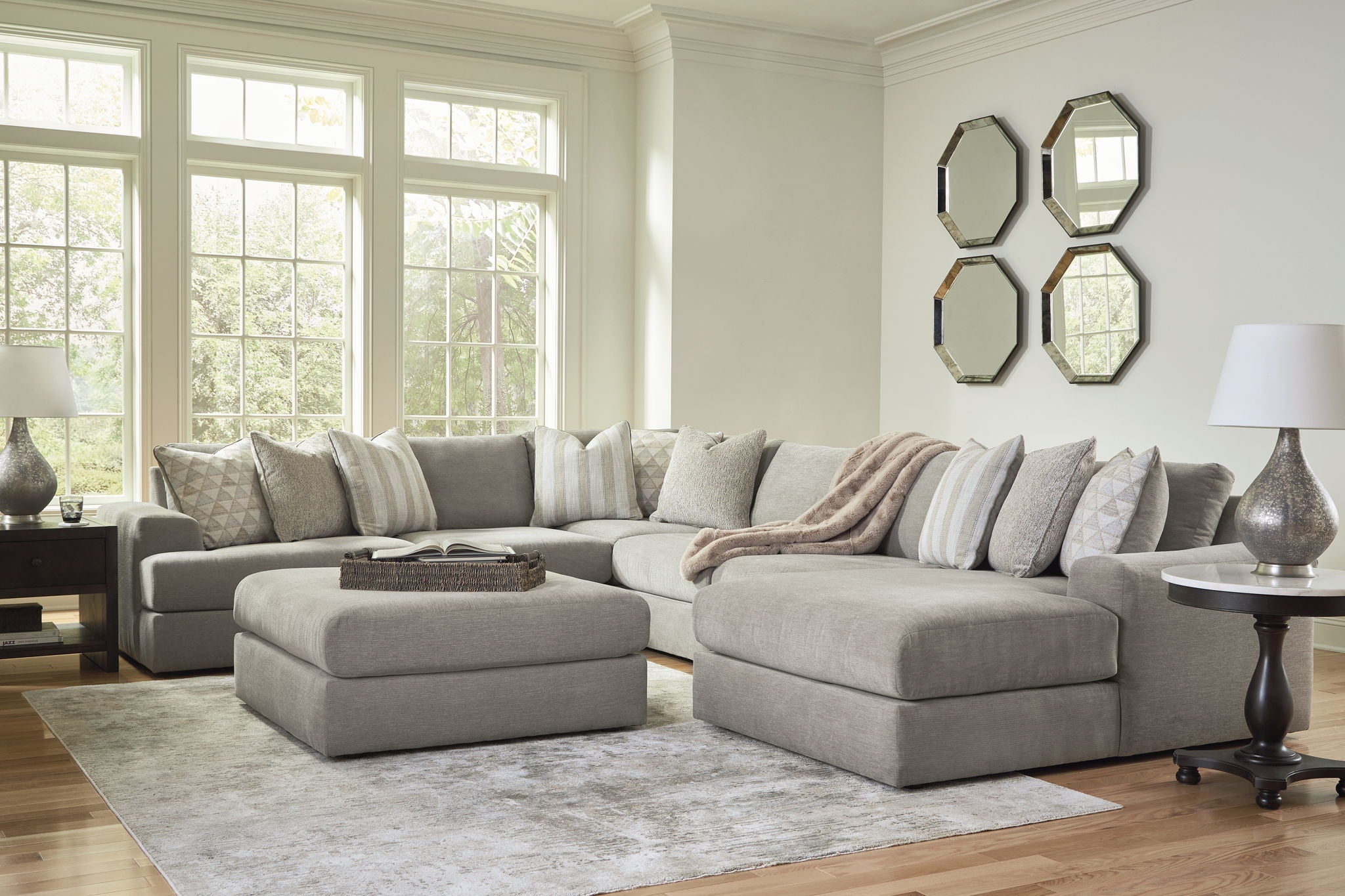 Dark gray sectional sofa with chaise and ottoman, plus patterned throw pillows