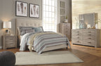 Gray five-drawer chest with metal bar pulls and tapered legs