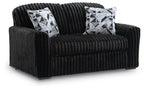 Black corduroy loveseat with two black-and-white geometric throw pillows