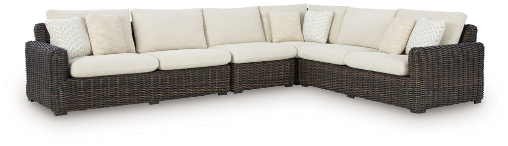 L-shaped outdoor sectional with dark brown wicker and beige seat cushions