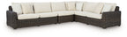 L-shaped outdoor sectional with dark brown wicker and beige seat cushions