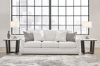 Light gray sofa with three seat cushions and several gray throw pillows