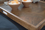 Brown wooden tray with side cutout handle, egg cups and mugs on top.