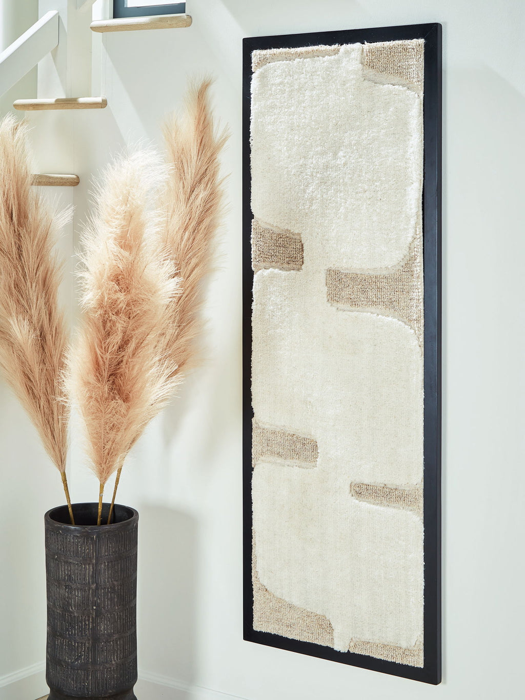 Vertical framed wall art with off-white textured panel and taupe blocks, black frame
