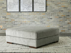 Gray oversized ottoman with ribbed fabric upholstery and square cushioned top
