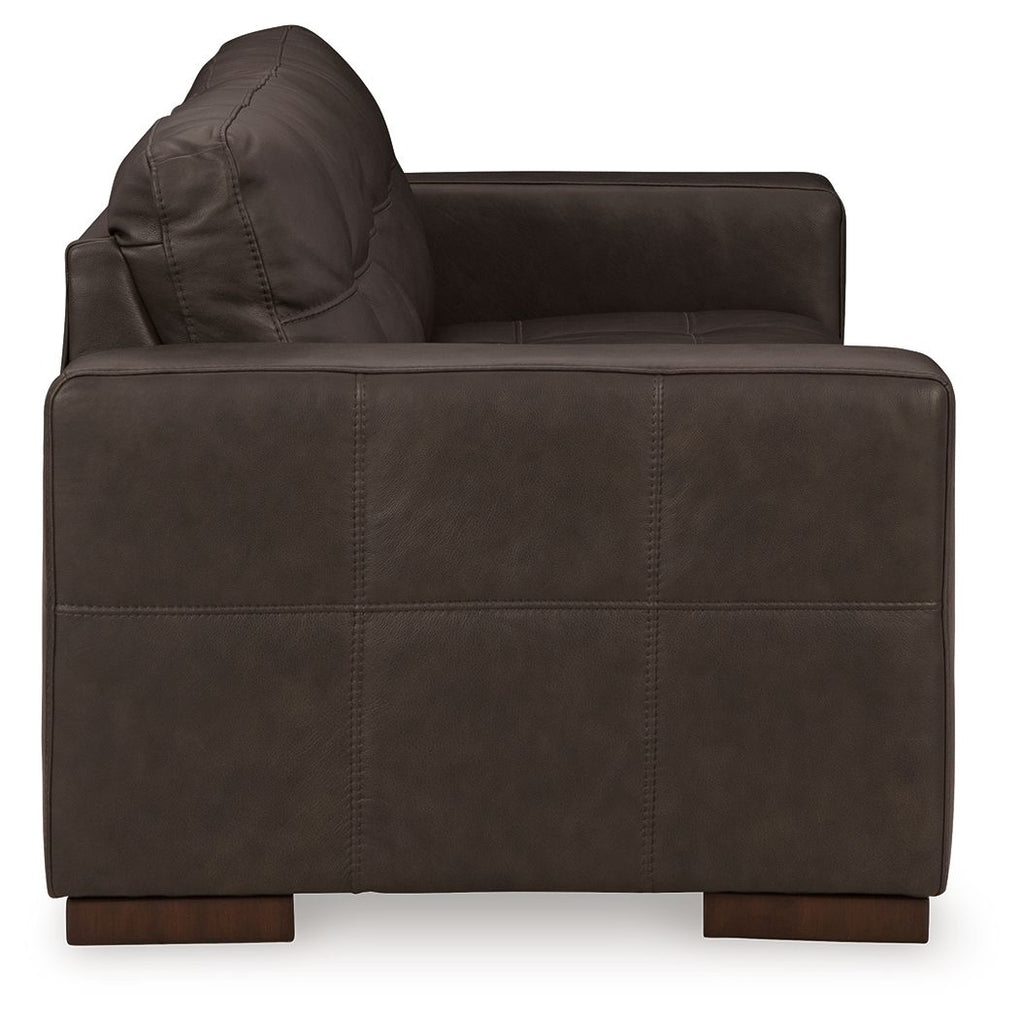 Dark brown fabric sofa with arched backrest and visible stitching seams