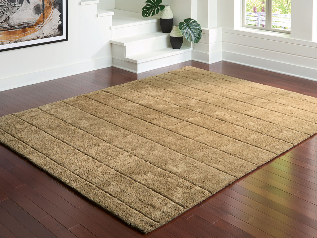 Light brown rug with geometric block motif and thin stitched detail border