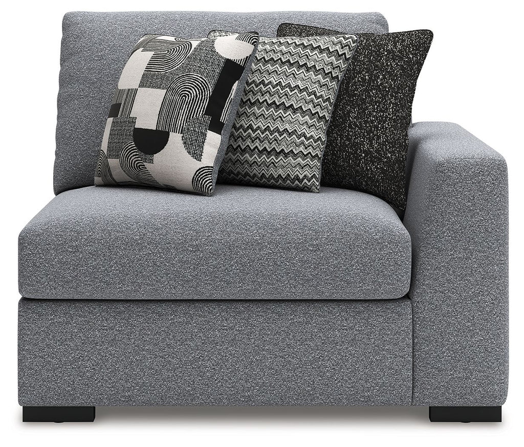 Gray corner accent chair with supportive armrests and two patterned decorative pillows