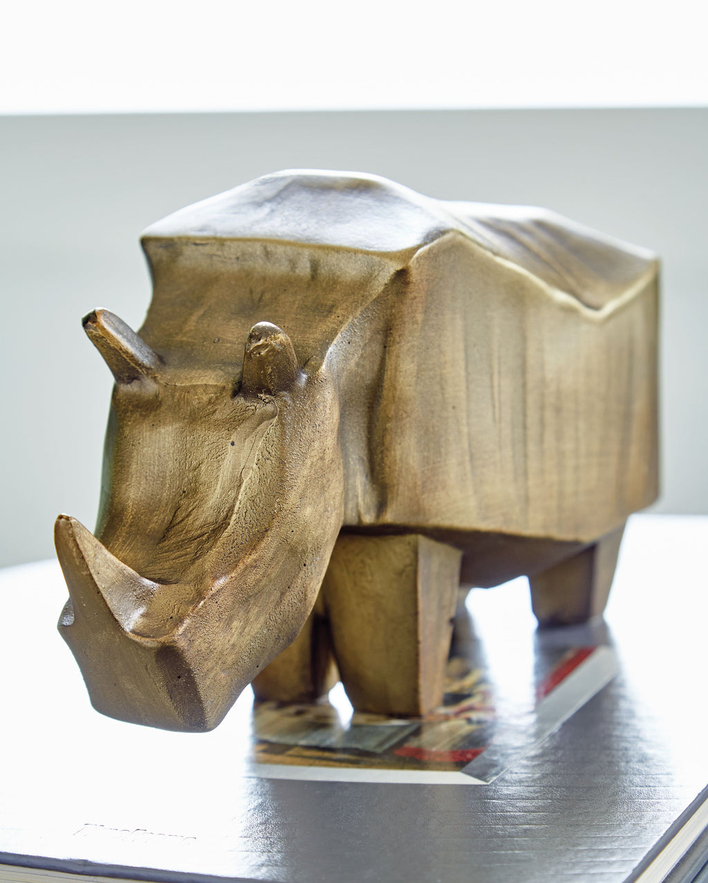 Antique gold elephant sculpture close-up, textured surface and upward trunk