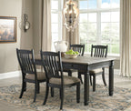 Dark gray dining table with four slat-back chairs and upholstered seat cushions