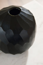 Black faceted vase with open neck and textured surface detail