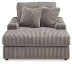 Corduroy chaise lounge chair in medium gray with three front cushions and two pillows.