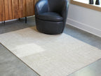 Light brown area rug with embossed geometric pattern