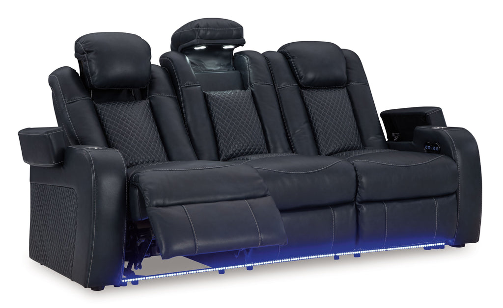 Power reclining sofa with adjustable headrests, dark navy upholstery, reclined seat