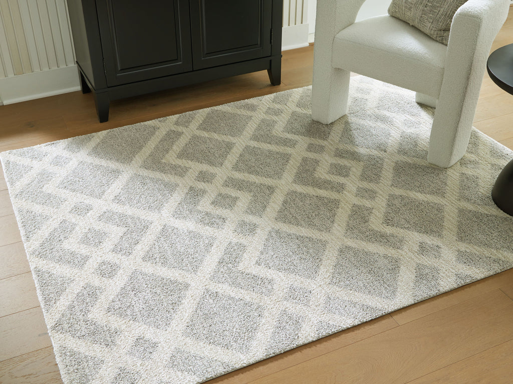 Gray geometric rug with repeating diamond pattern, laid flat on floor