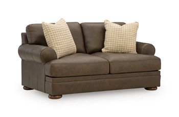 Dark brown loveseat with two patterned throw pillows, rounded arms, and wooden legs