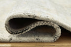 Close-up of rug backing fold showing underside of cream and gray pile
