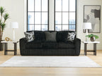 Dark corduroy loveseat with two patterned throw pillows and a solid center back cushion.