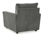 Dark gray upholstered armchair with thick backrest and block arms.