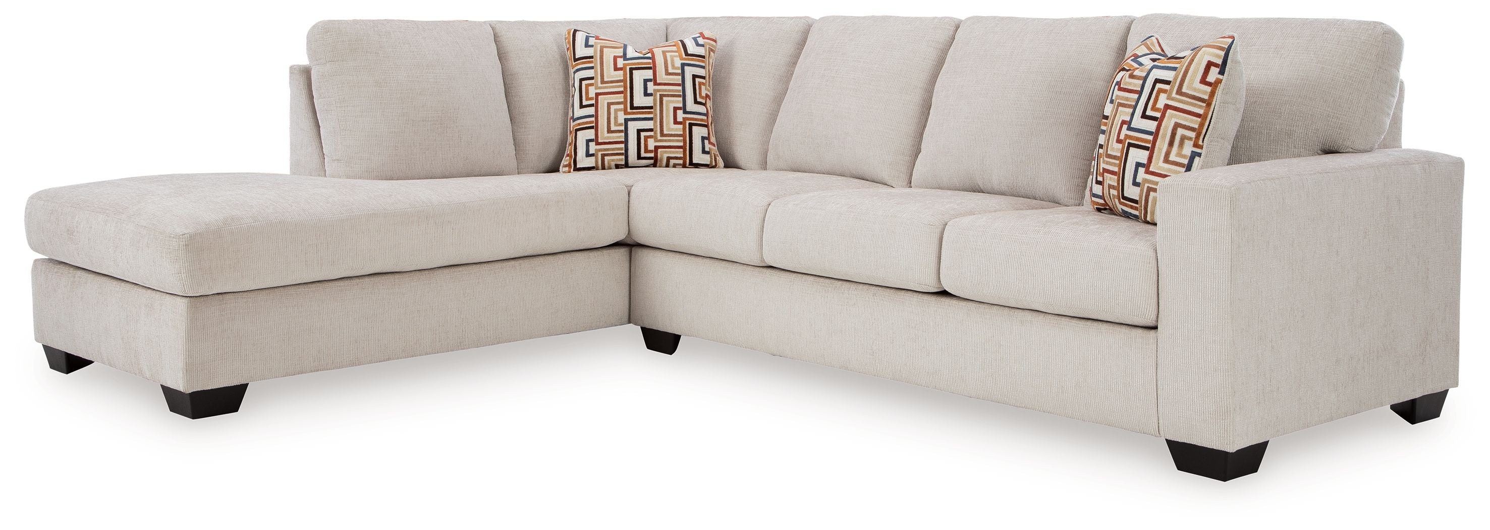 Light stone sectional sofa with corner chaise and three geometric accent cushions