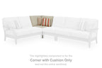 White sectional corner with a beige cushion and two throw pillows