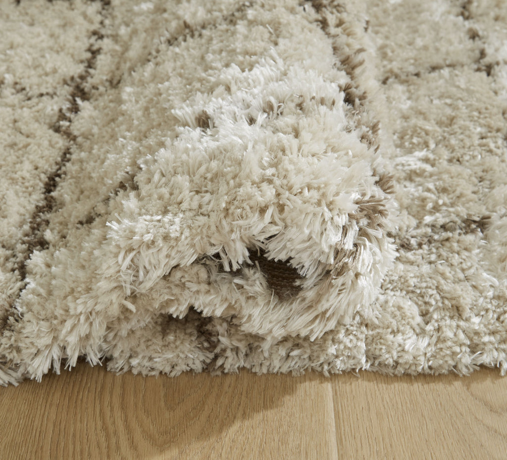 Beige high-pile shag rug with fringed edge and subtle grid lines