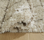 Beige high-pile shag rug with fringed edge and subtle grid lines
