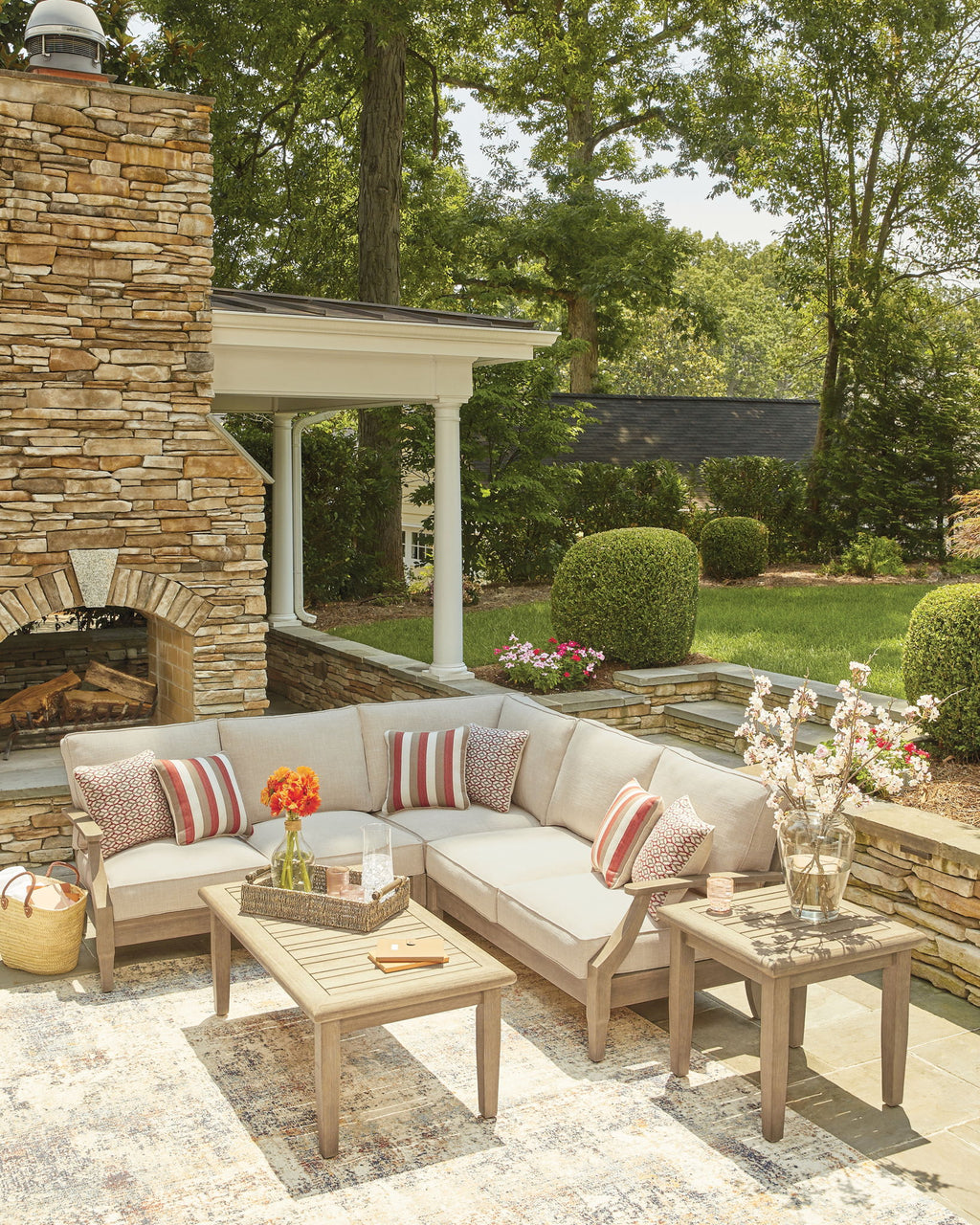 Beige outdoor sectional sofa with striped pillows and patterned accent cushions, low back
