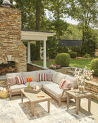 Beige outdoor sectional sofa with striped pillows and patterned accent cushions, low back