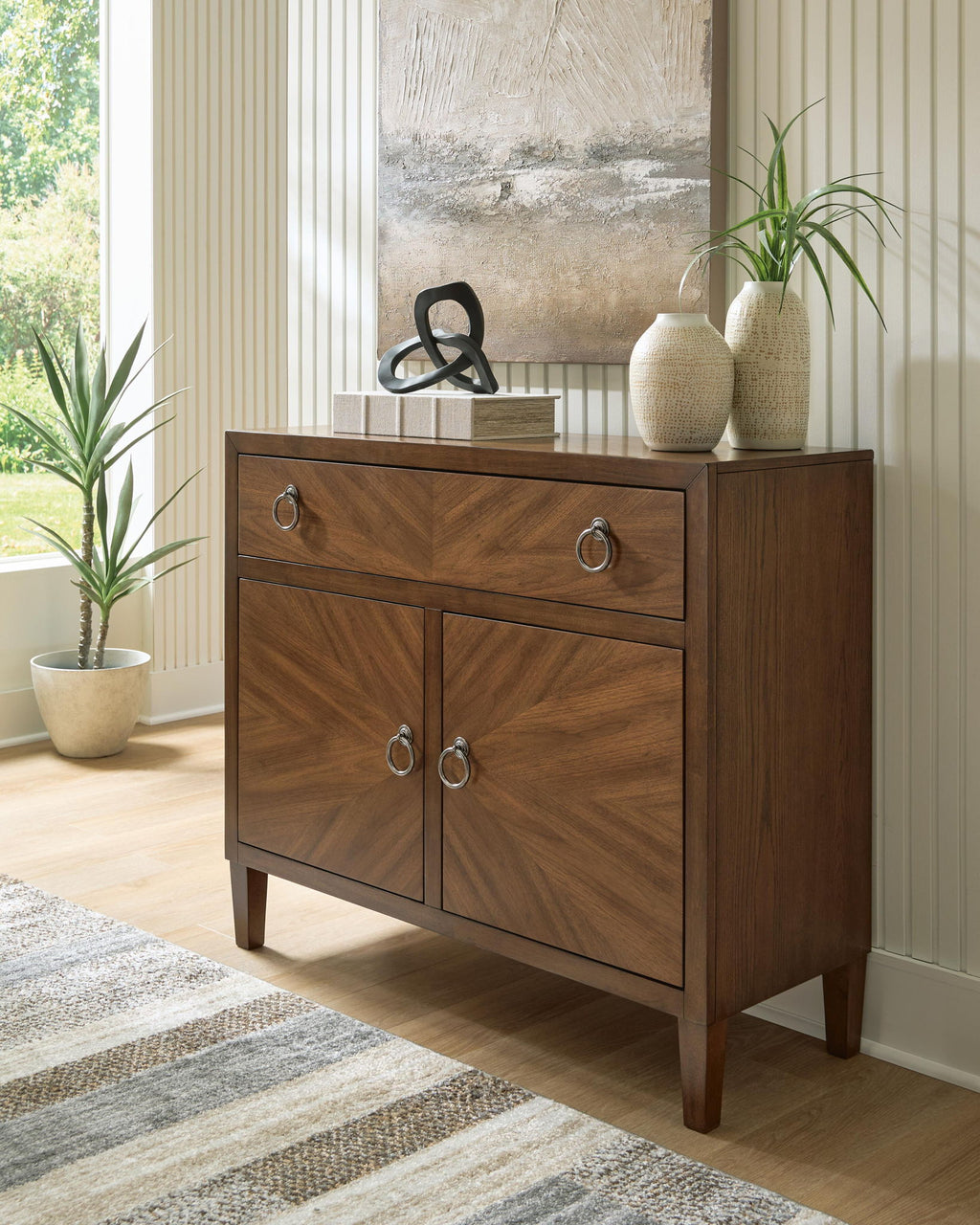 Medium brown accent cabinet with drawer and two cabinet doors, round metal handles