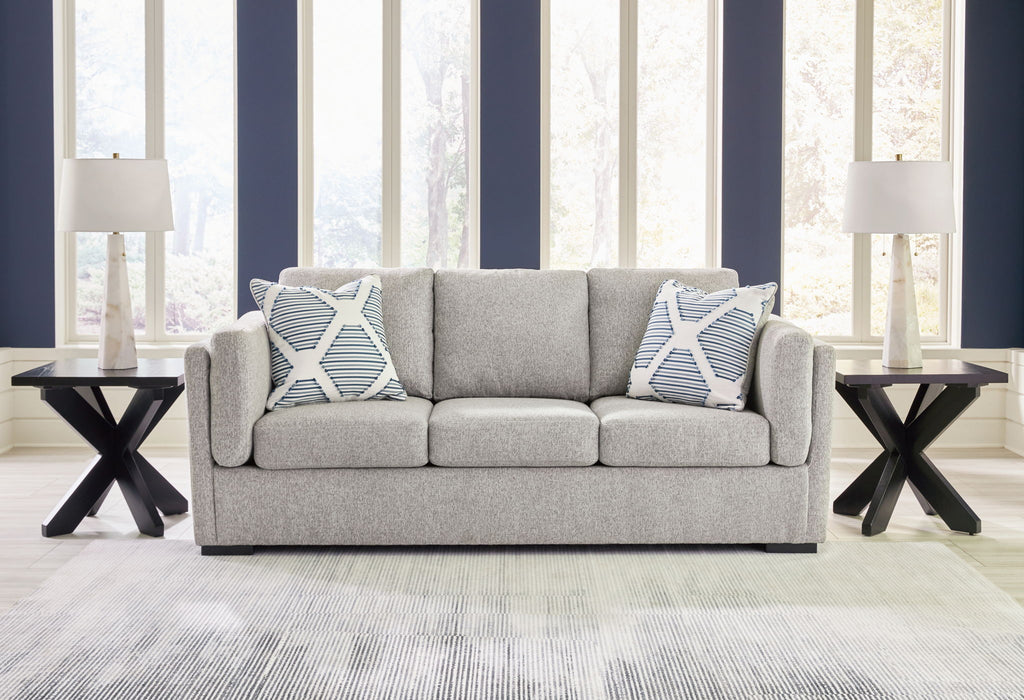 Gray living room sofa set with two patterned throw pillows and matching armchair ottoman