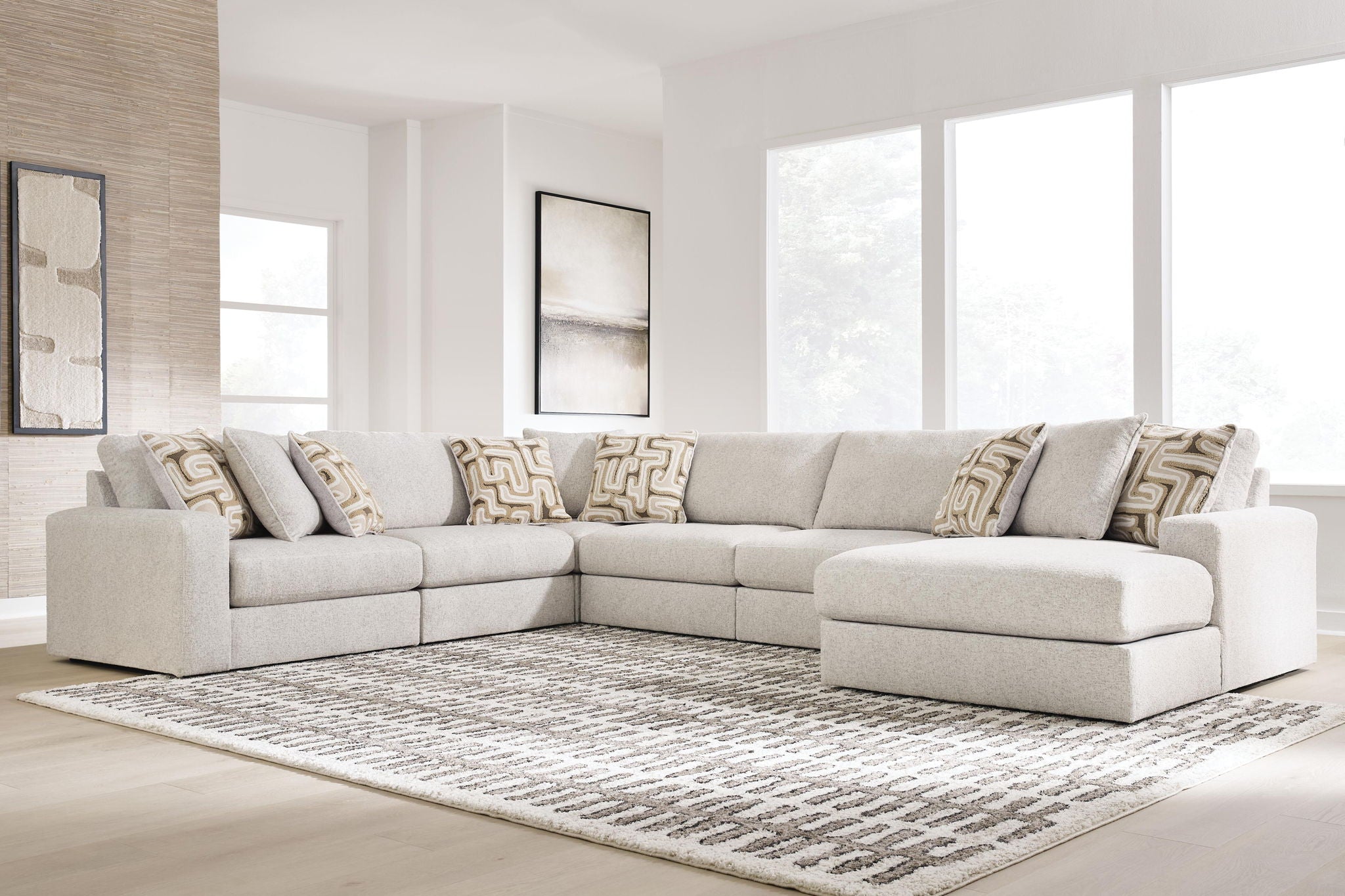 Light beige sectional sofa with corner chaise and patterned throw pillows.