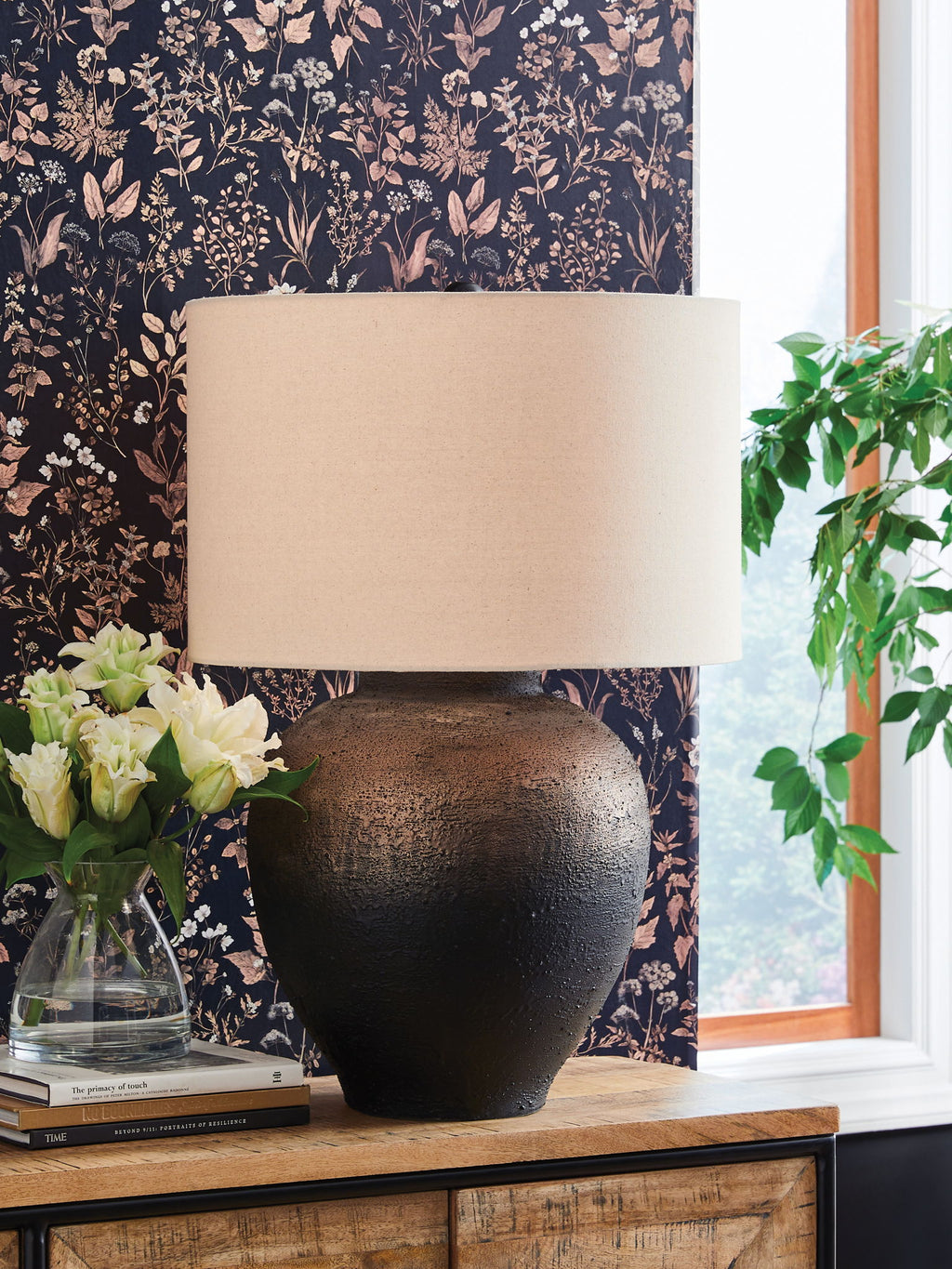 Brown and black metal table lamp on side table with drum fabric shade