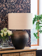 Brown and black metal table lamp on side table with drum fabric shade