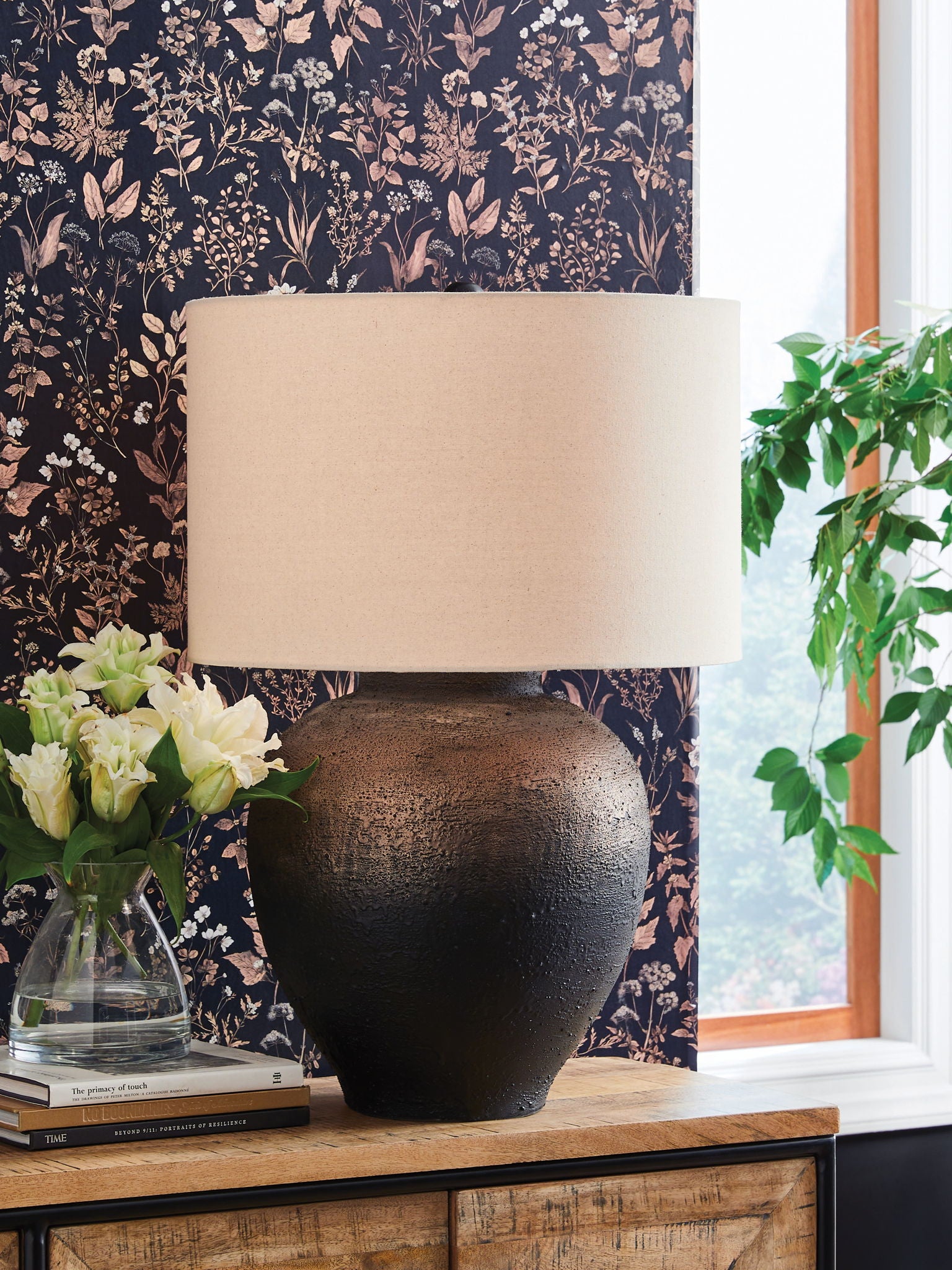 Brown and black metal table lamp on side table with drum fabric shade