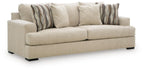 Beige upholstered sofa with two seat cushions and striped throw pillows