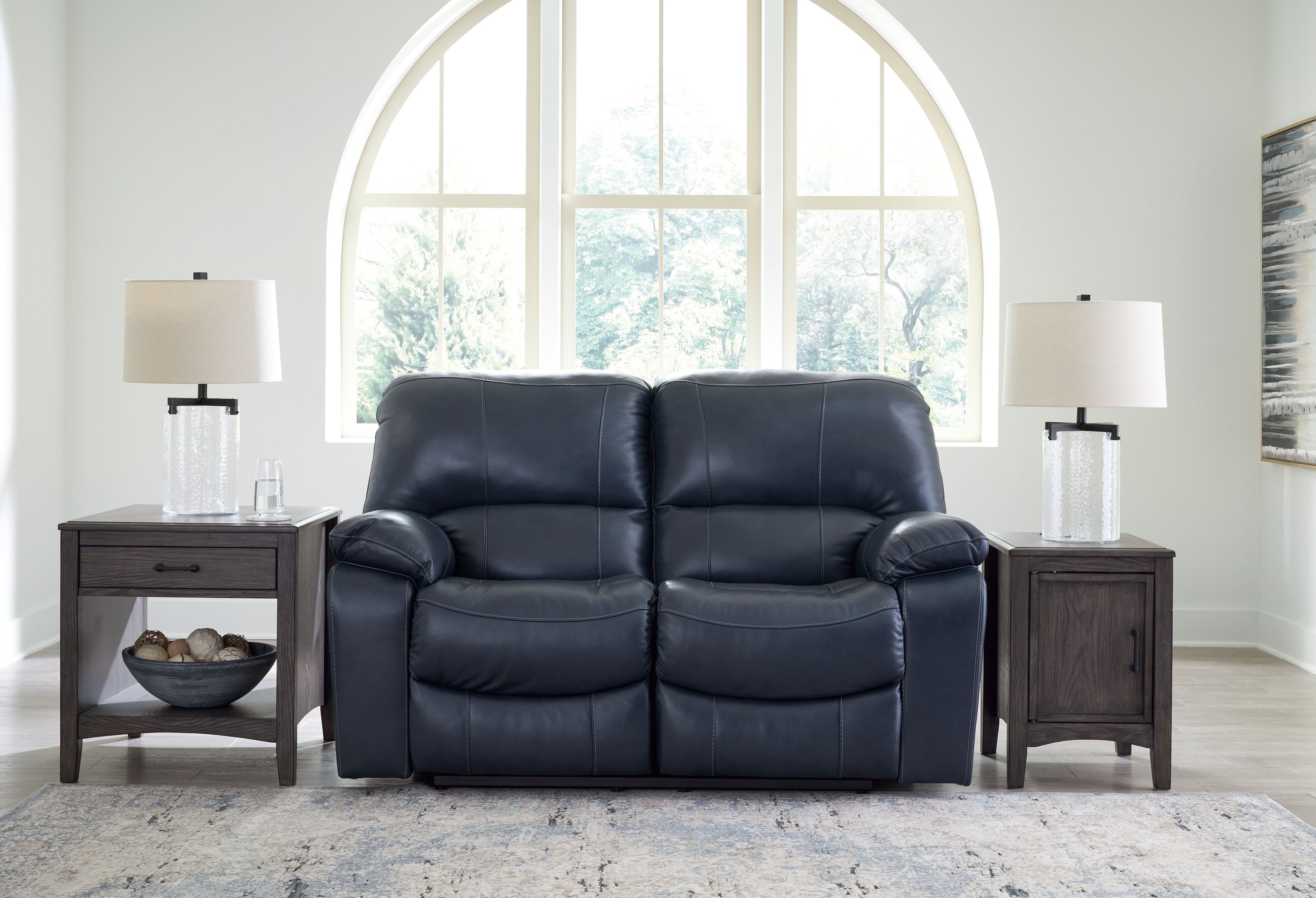 Power reclining loveseat, dark blue faux leather with cushioned back and padded arms