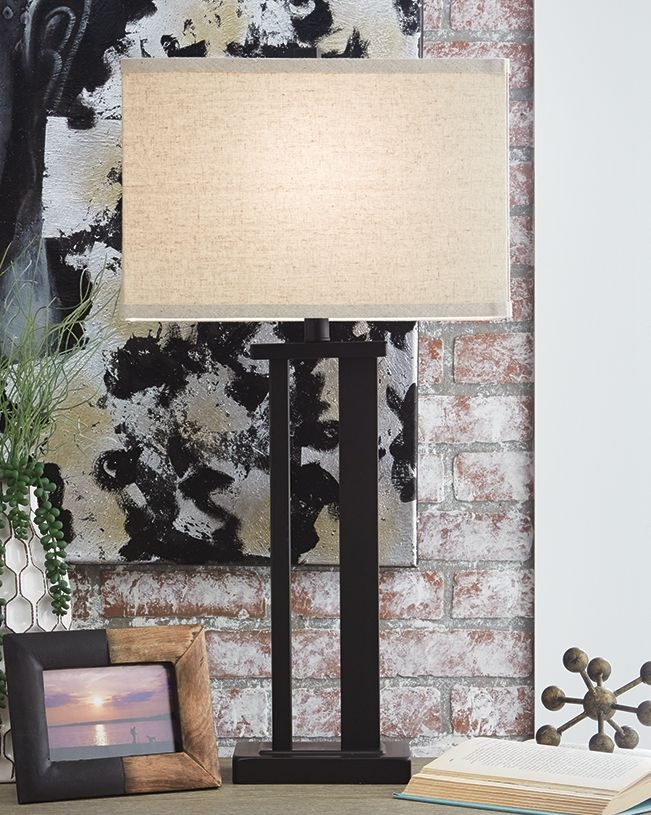 Black metal table lamp with light beige fabric shade and pedestal base
