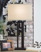 Black metal table lamp with light beige fabric shade and pedestal base