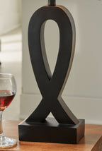 Black table lamp with white square shade and ribbon-shaped base