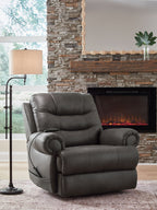 Dark gray leather-look power lift recliner beside fireplace with padded head and arms