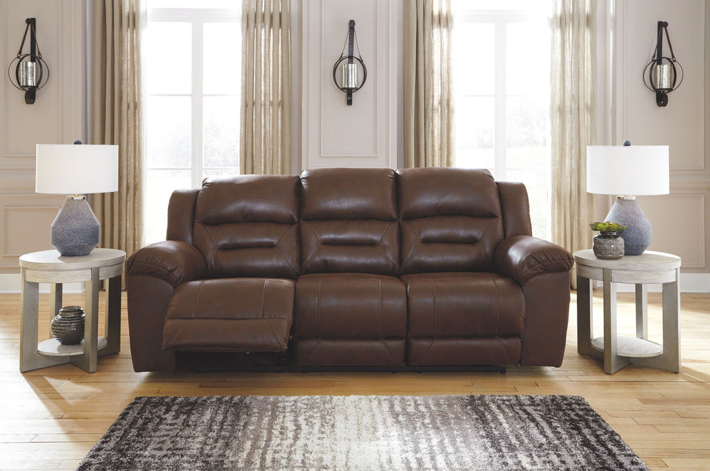 Power reclining sofa in dark brown leather with three padded headrests and arms