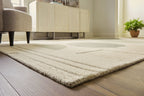 Ivory area rug with subtle line border and abstract ovals in gray and sage