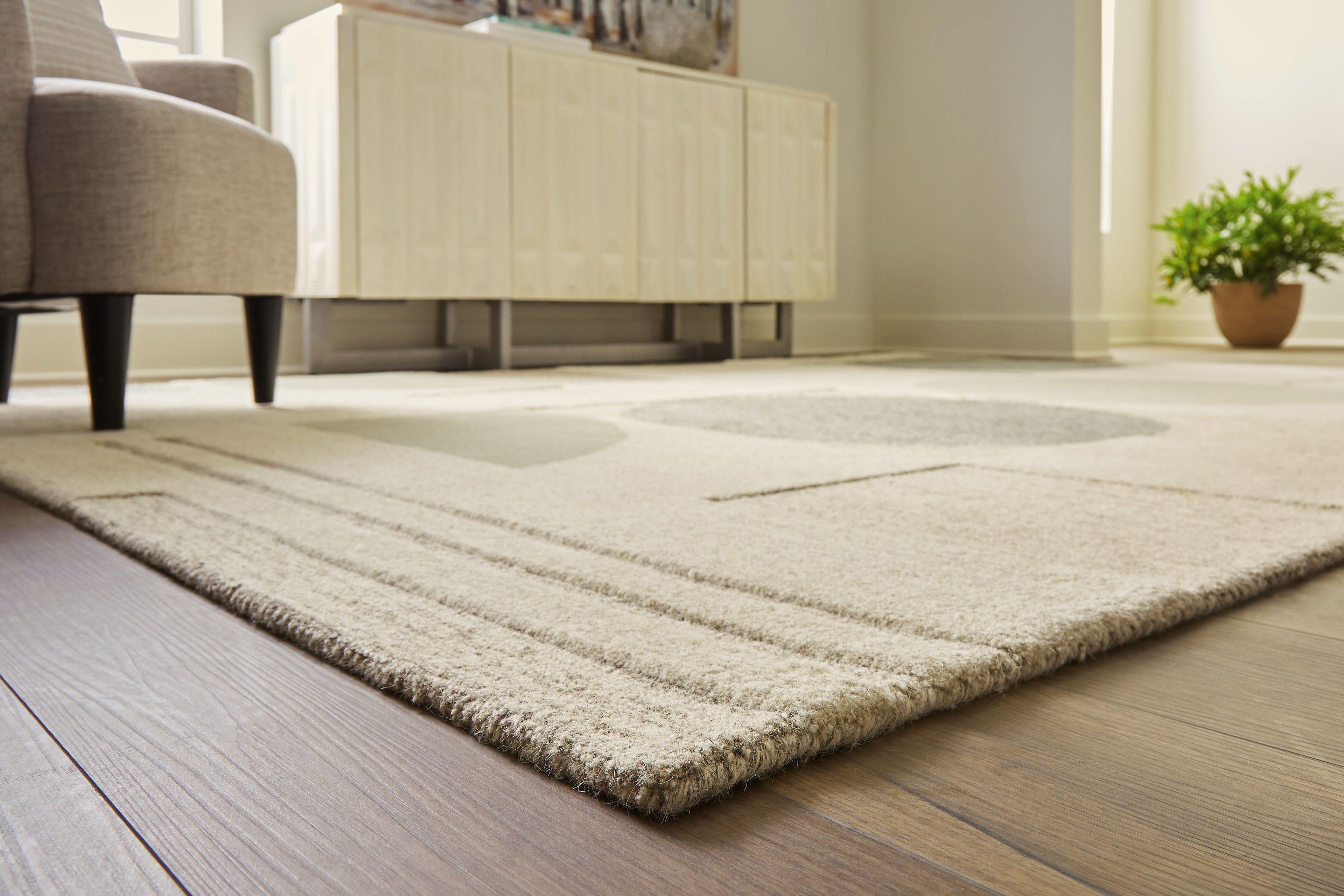 Ivory area rug with subtle line border and abstract ovals in gray and sage